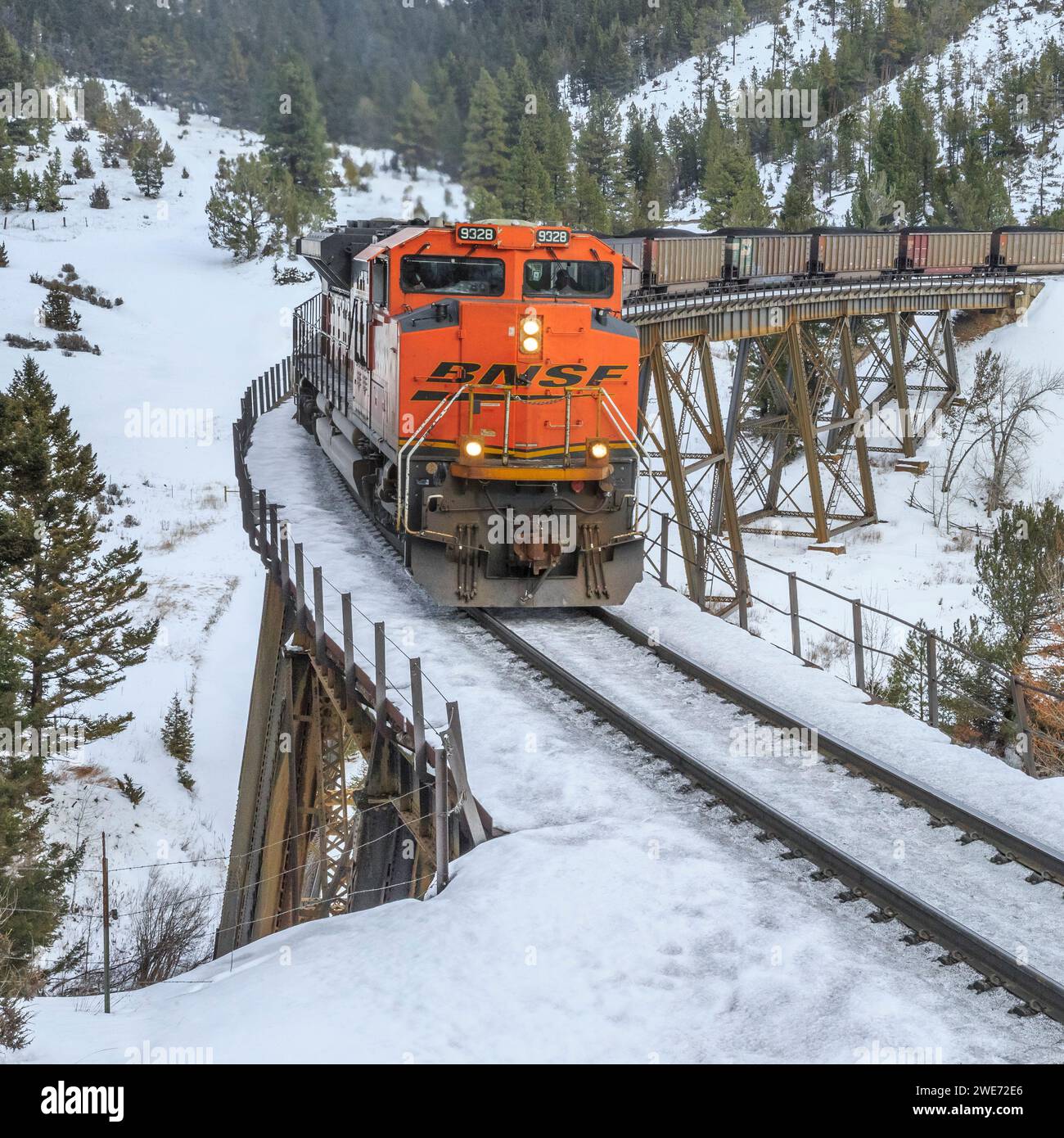 il treno che trasporta le carrozze a carbone verso mullan passa sopra un cavalletto in inverno vicino ad austin, montana Foto Stock