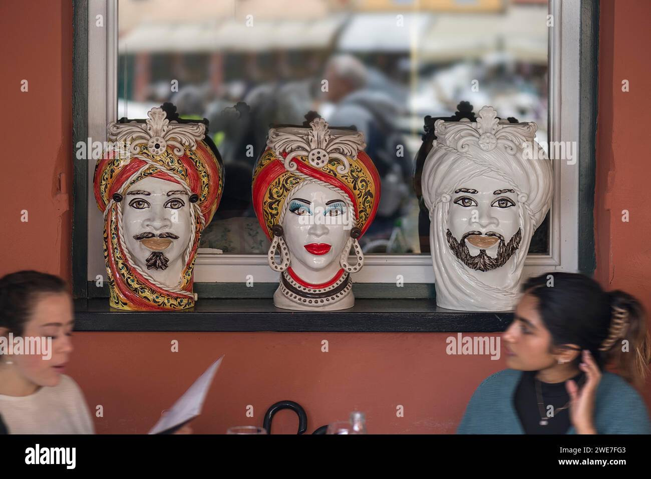 Vasi decorativi disegnati con volti indiani, nella finestra di un ristorante indiano, Portofino, Italia Foto Stock