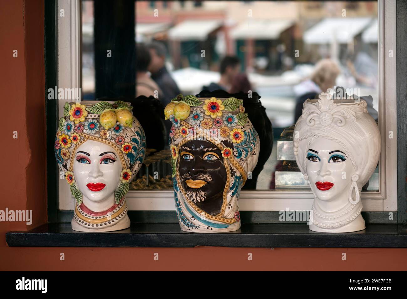 Vasi decorativi disegnati con volti indiani, nella finestra di un ristorante indiano, Portofino, Italia Foto Stock