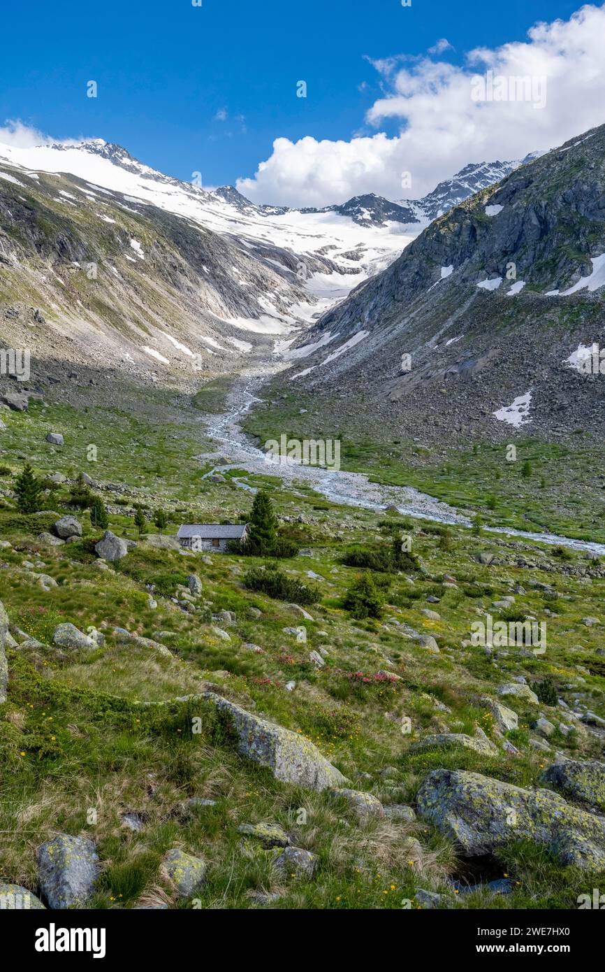 Pittoresco paesaggio montano, dietro la cima della montagna con neve e ghiacciaio Hornkees, valle con Hornkeesbach, Berliner Hoehenweg, Alpi Zillertal Foto Stock