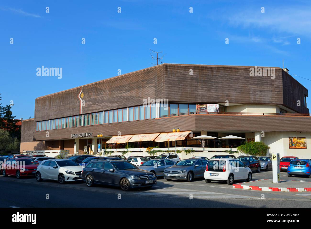 Edificio moderno con parcheggio pieno di auto sotto un cielo azzurro, Casa della Cultura, Pezinok, Boesing, Bratislavsky kraj, Slovacchia Foto Stock