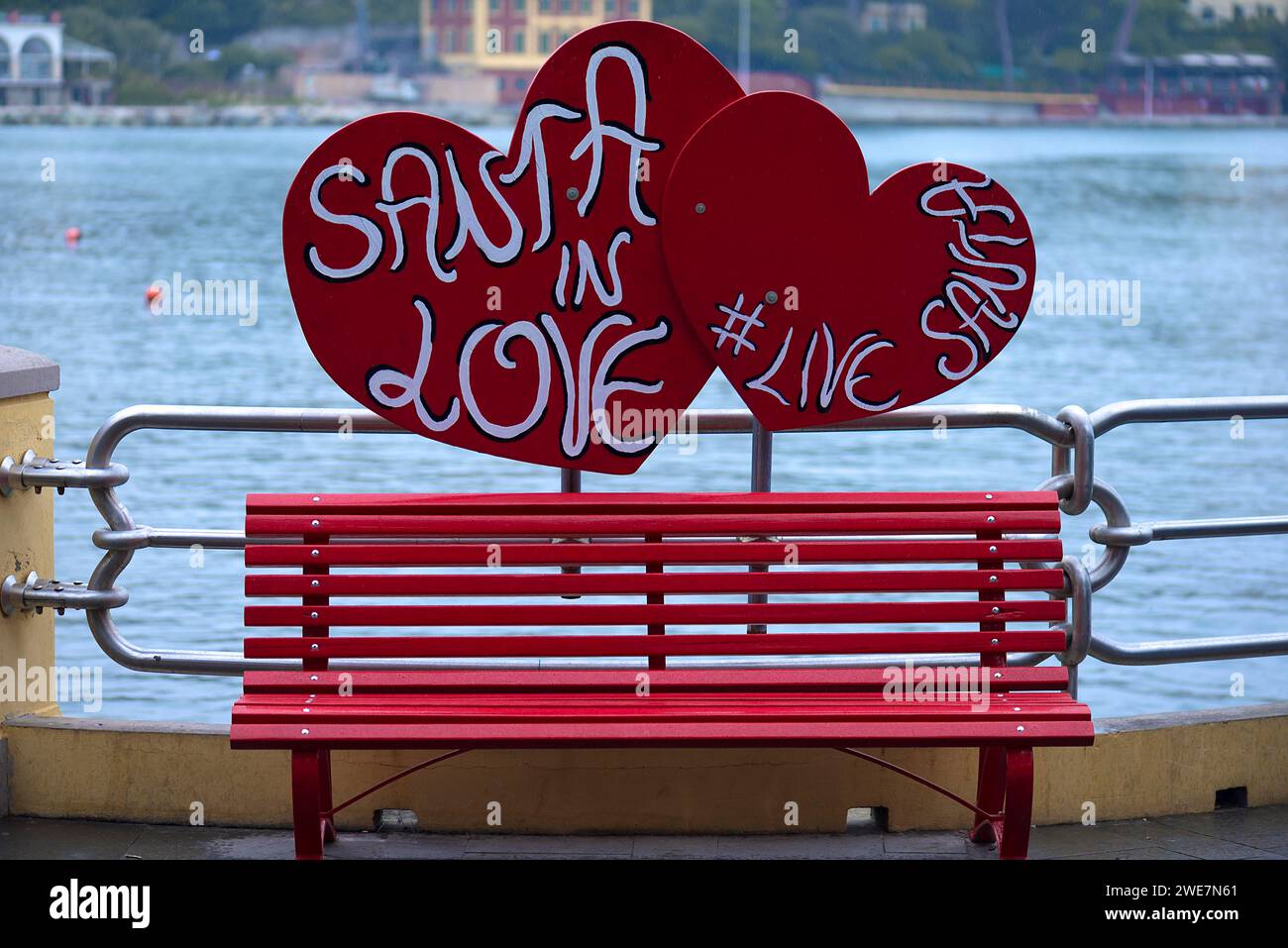 Panca rossa, dietro di essa cuora con la scritta: Babbo Natale in amore, al porto di Portofino, Italia Foto Stock