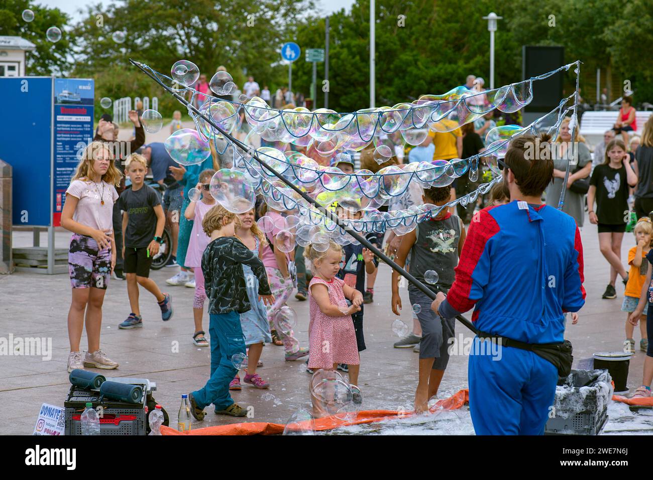 Man mostra bolle di sapone ai bambini sul lungomare di Kuehlungsborn, Meclemburgo-Vorpommern, Germania Foto Stock