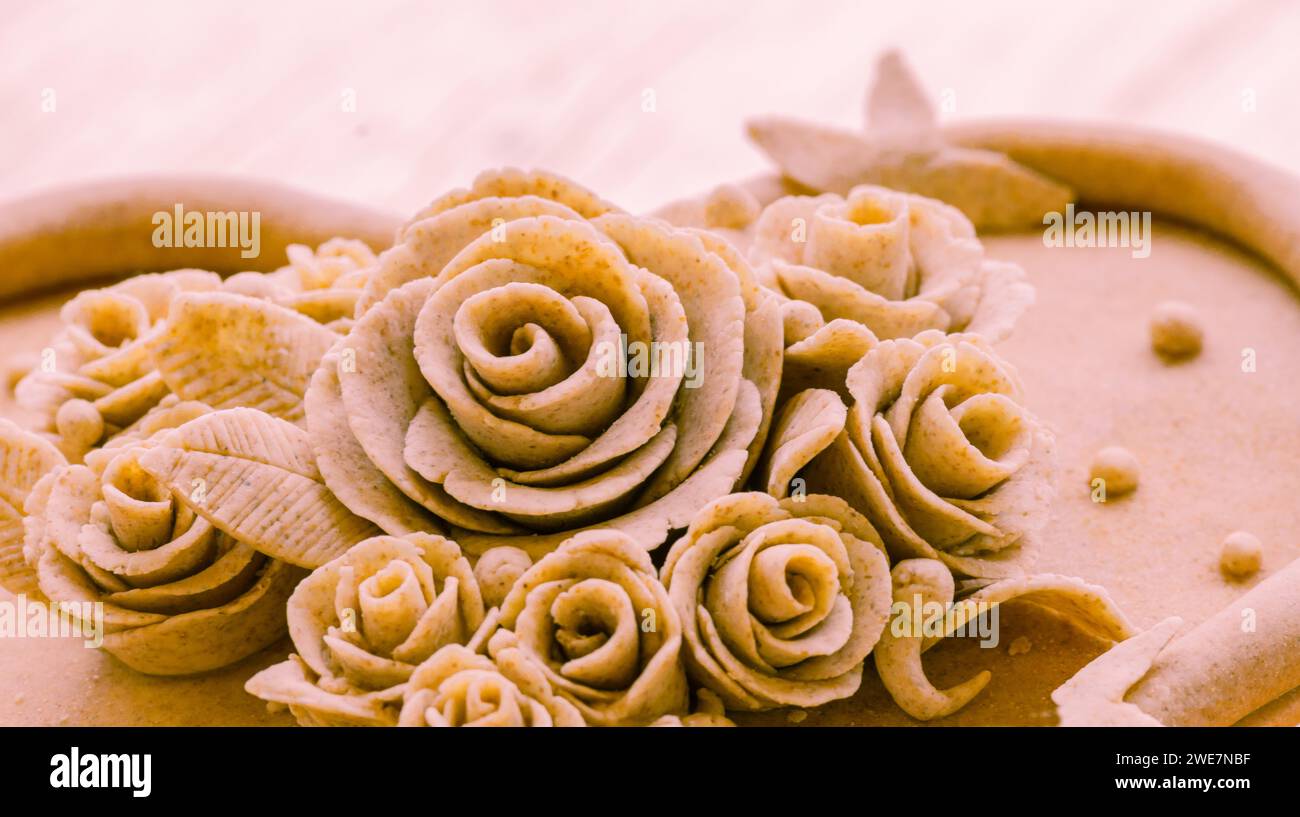 Primo piano di motivi di rosa sculture di impasti beige, Teig, gebacken Foto Stock