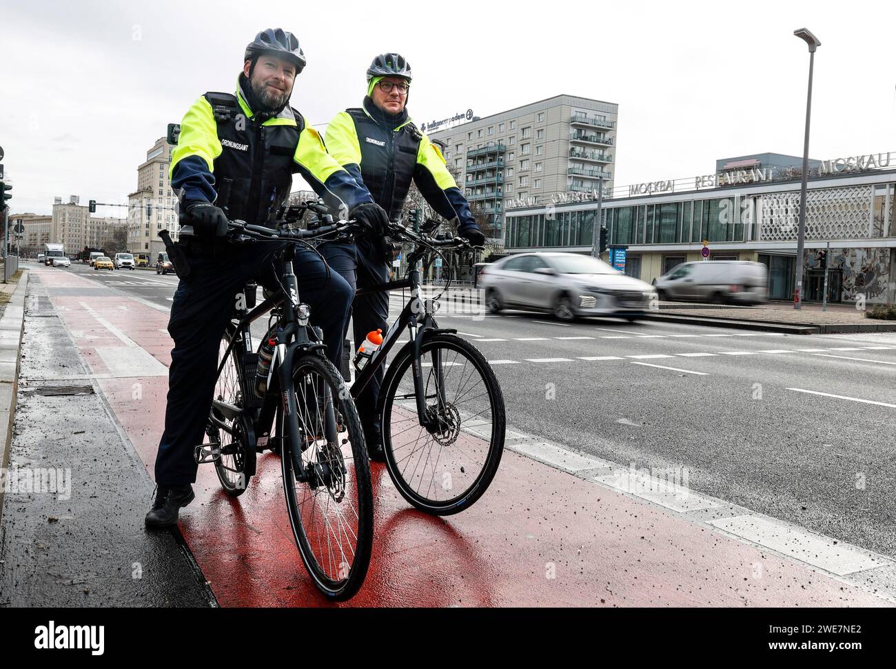 Dipendenti dello squadrone di biciclette dell'ufficio dell'ordine pubblico con le loro biciclette in strada. Lo squadrone di biciclette dell'ufficio dell'ordine pubblico a Mitte Foto Stock