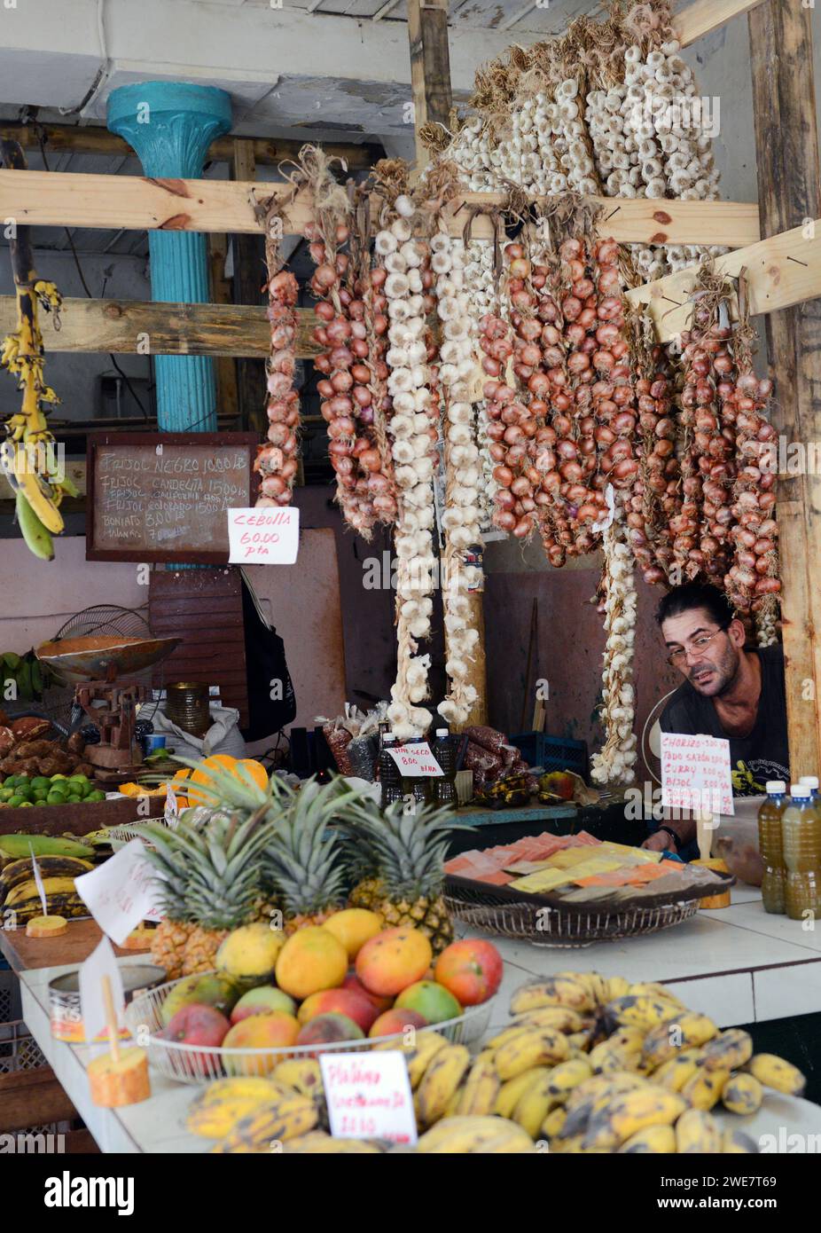 Un cubano che vende aglio, cipolle e altre verdure in un piccolo negozio a l'Avana vecchia, Cuba. Foto Stock