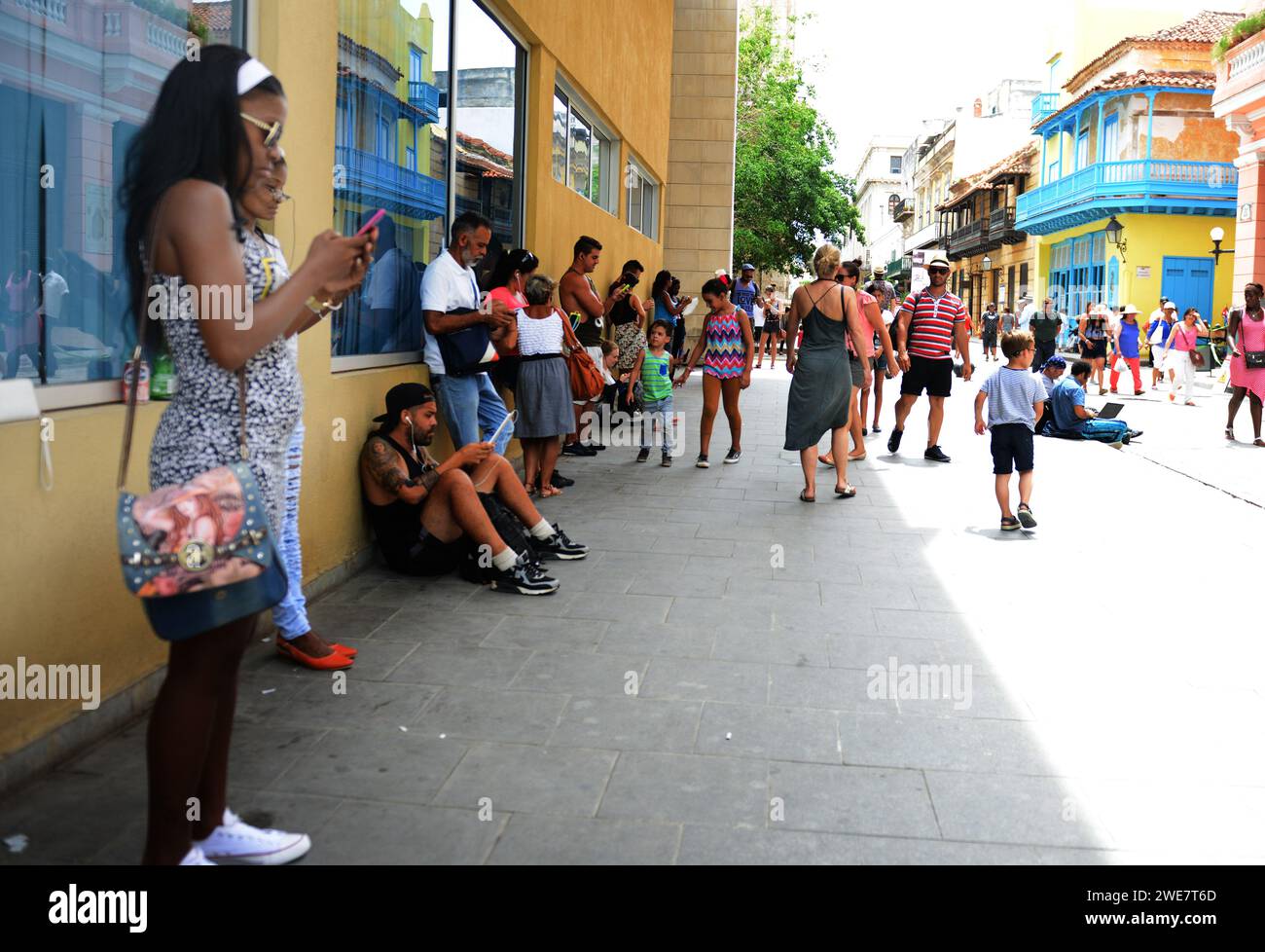 Persone che rilevano il segnale wi-fi sui telefoni cellulari nella vecchia Avana, Cuba. Foto Stock