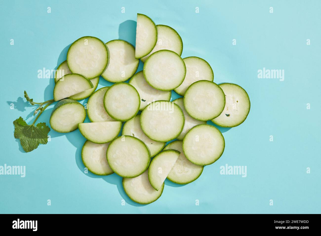 Sullo sfondo azzurro, vengono decorate molte fette di melone fresco invernale. Melone invernale (Benincasa hispida) ha molti benefici per la salute, ha Foto Stock