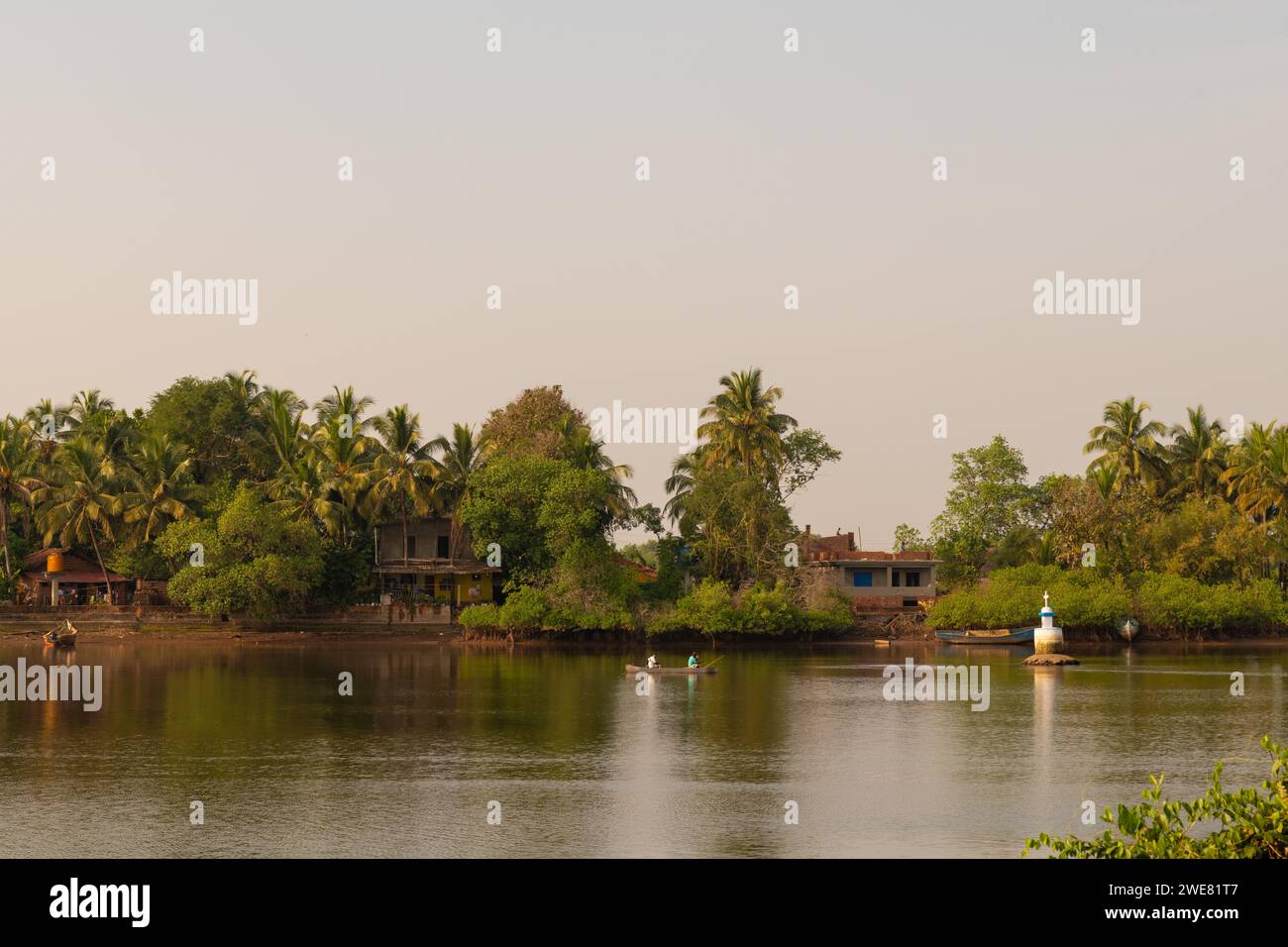 Vita rurale in un villaggio di pescatori a Goa con un fiume calmo al tramonto. Foto Stock