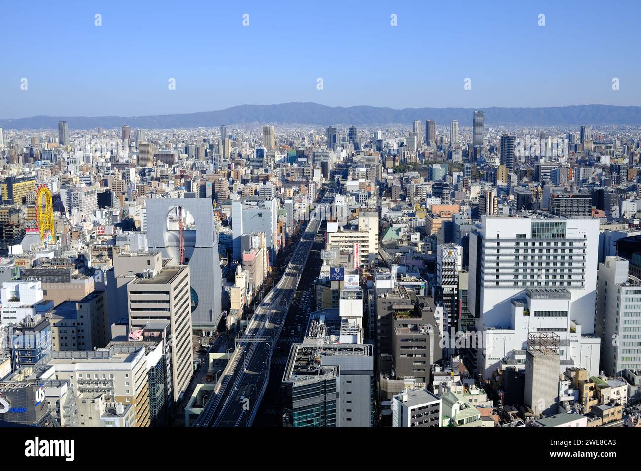 Un'ampia vista aerea cattura la fitta struttura urbana di Osaka, in Giappone, con un cielo limpido in alto Foto Stock