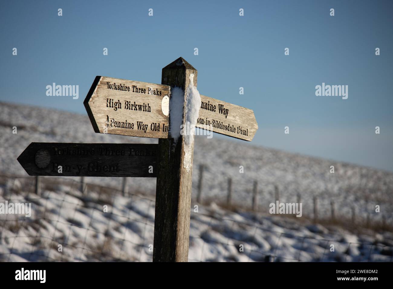Un cartello per la strada Yorkshire Three Peaks e la Pennine Way vicino a High Birkwith in inverno nel Parco Nazionale Yorkshire Dales in Inghilterra. Foto Stock
