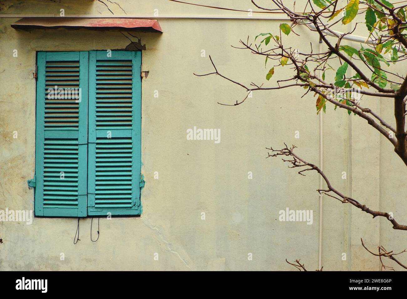 Finestra minimalista turchese su un muro giallo Foto Stock