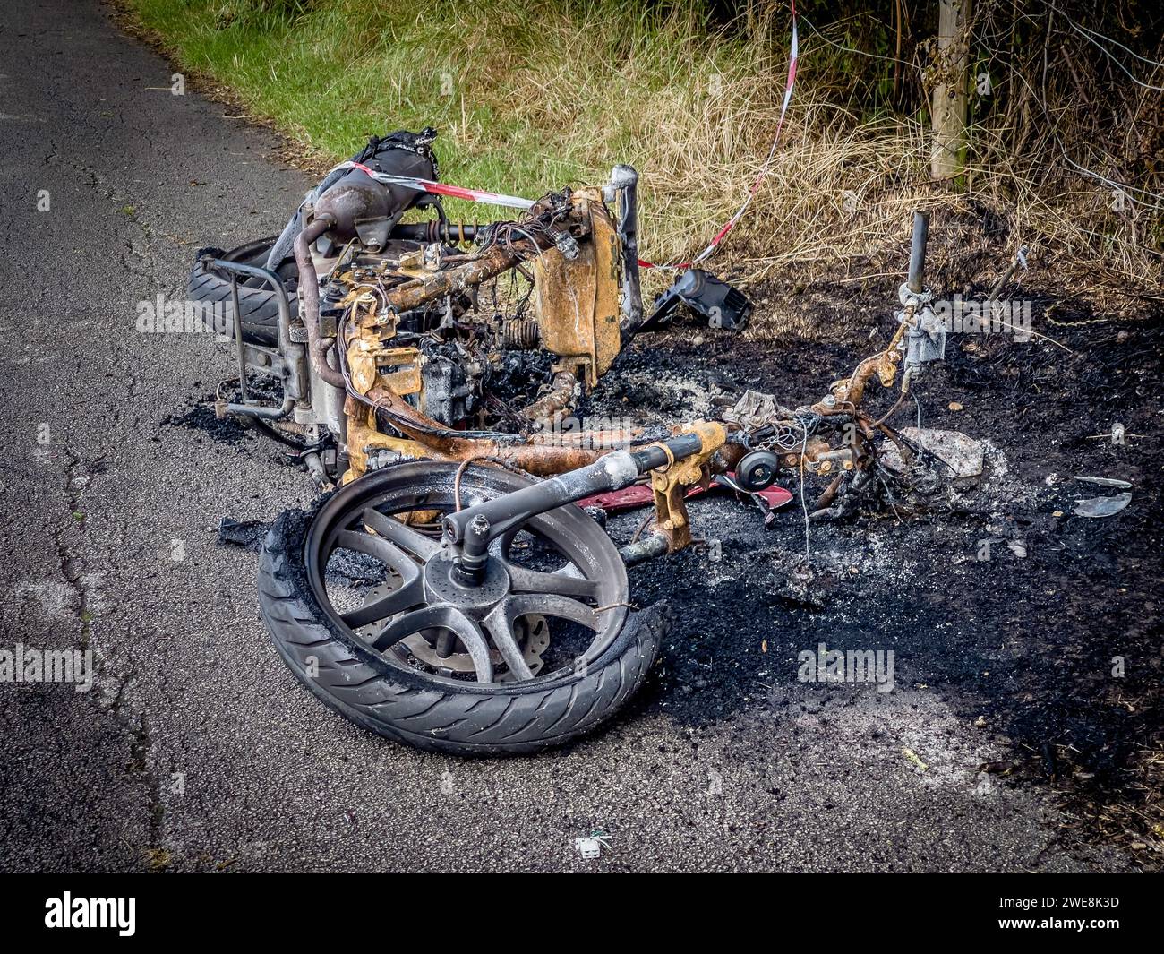 Moto rubata bruciata sul bordo di una strada. Foto Stock