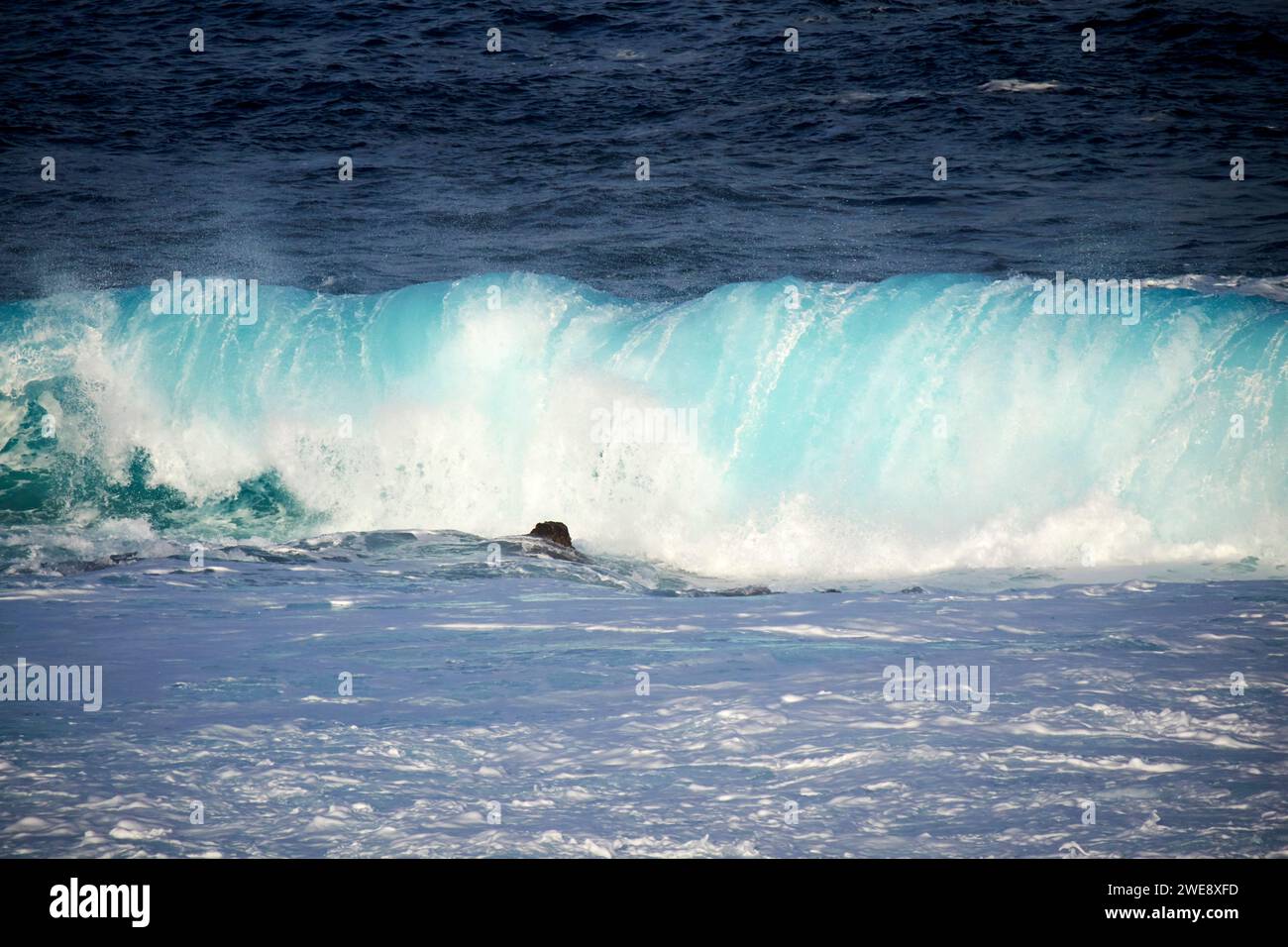 onde blu del mare che si infrangono su coste rocciose poco profonde sulla costa atlantica delle isole canarie di lanzarote in spagna Foto Stock