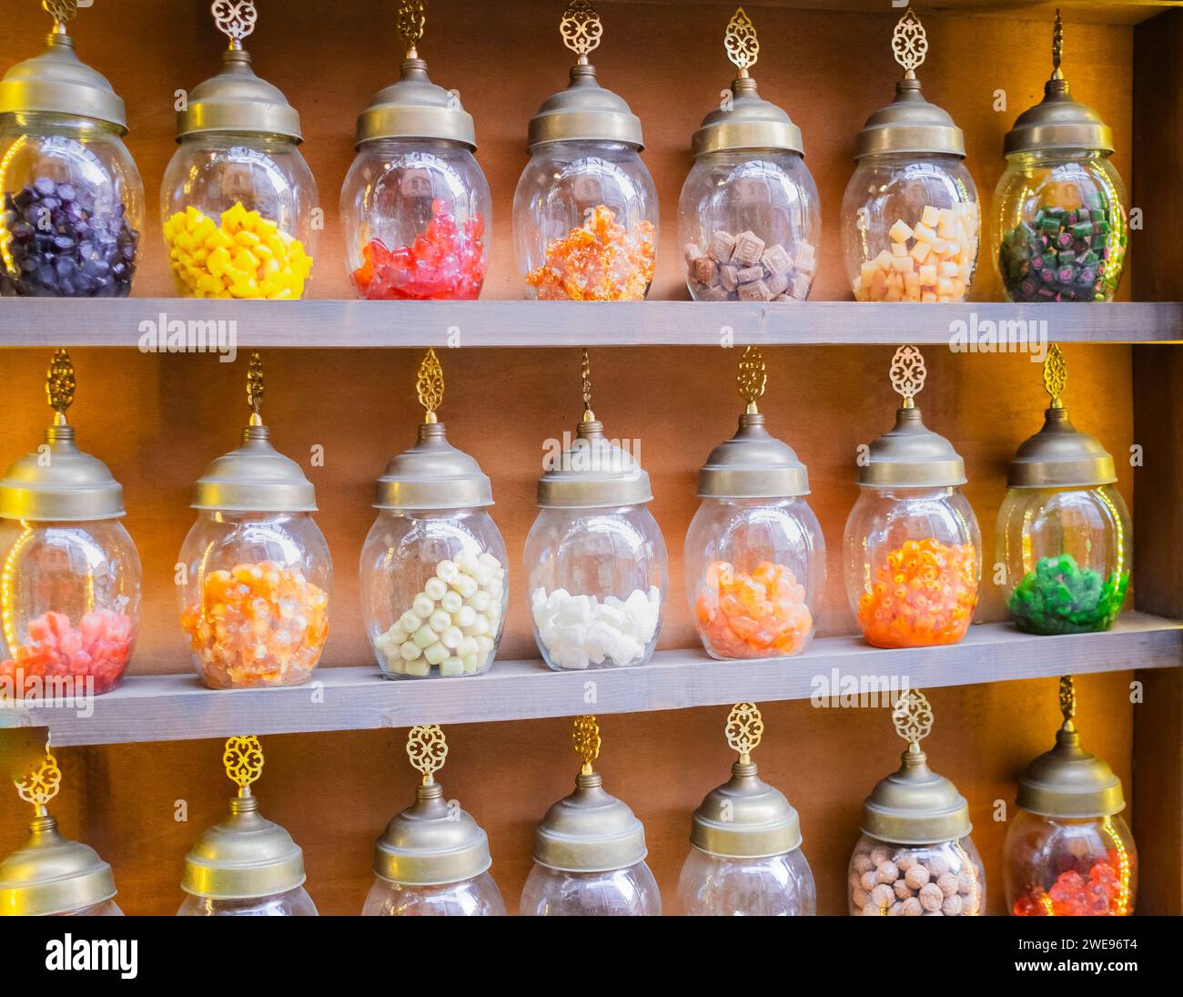 Bellissimi vasetti pieni di deliziosi e colorati dessert, delizie turche, su sfondo arancione. Negozio di dolci turchi. Caramelle in un barattolo. Un barattolo di dolce, disidratatore Foto Stock