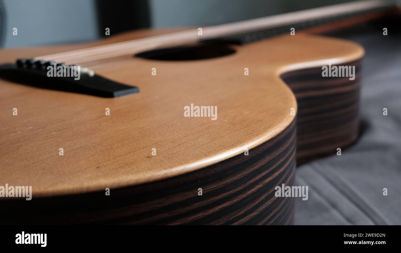 Un primo piano della chitarra acustica ab ripresa da un lato e da un angolo basso Foto Stock