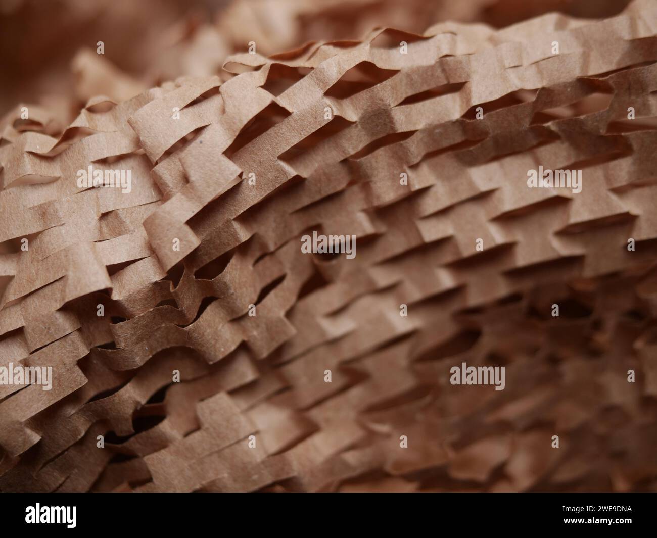 Stucco di carta per pacchi. Carta da imballaggio a nido d'ape marrone Kraft con fessure. Primo piano di carta da artigianato schiacciata. Carta da costruzione riciclata. Posiziona per testo Foto Stock