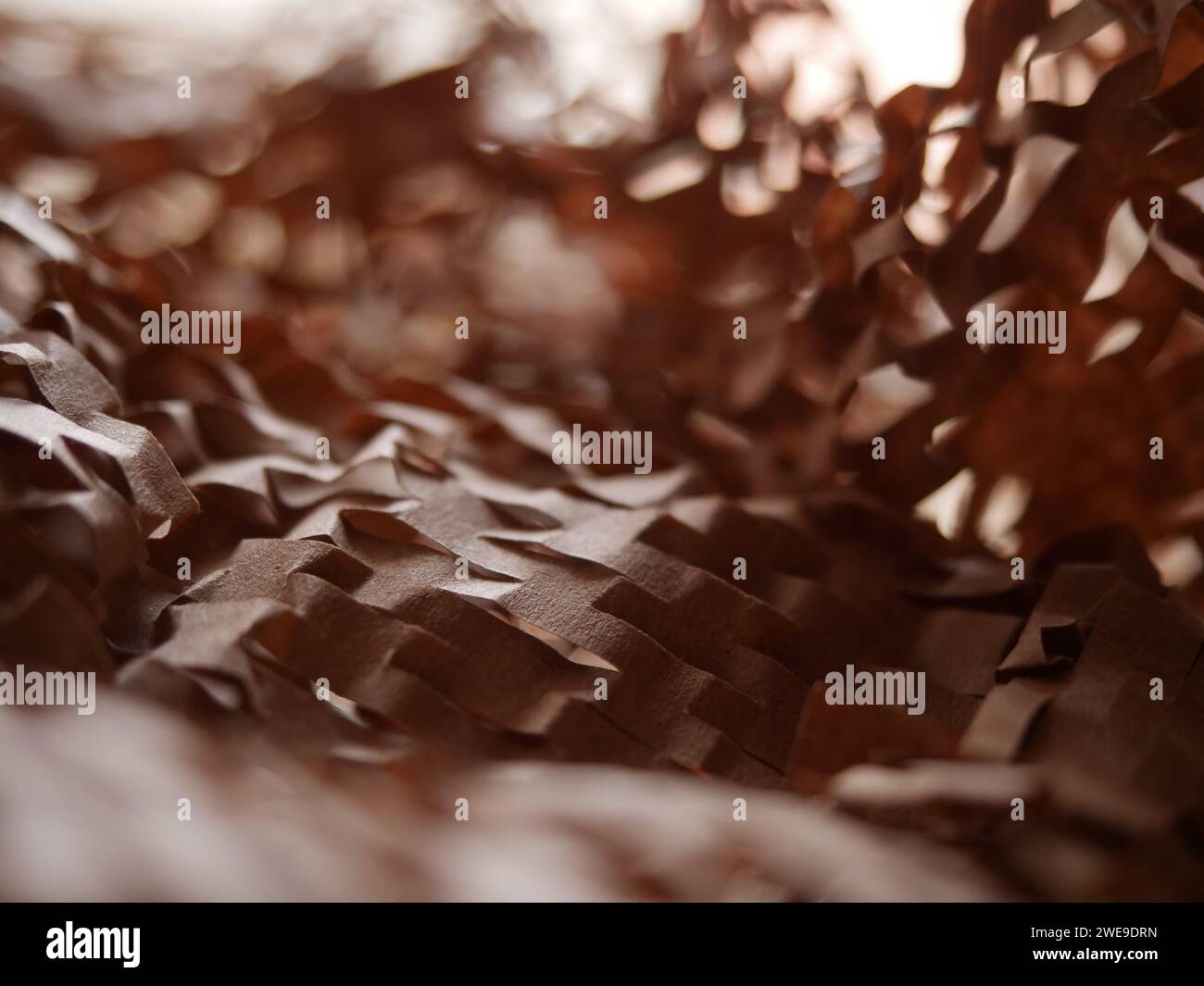 Stucco di carta per pacchi. Carta da imballaggio a nido d'ape marrone Kraft con fessure. Primo piano di carta da artigianato schiacciata. Carta da costruzione riciclata. Posiziona per testo Foto Stock