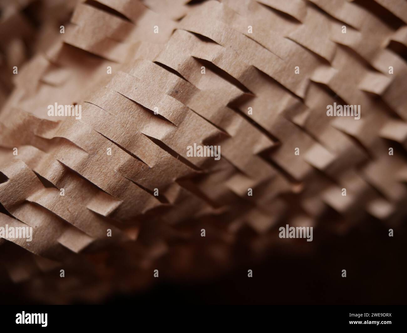 Stucco di carta per pacchi. Carta da imballaggio a nido d'ape marrone Kraft con fessure. Primo piano di carta da artigianato schiacciata. Carta da costruzione riciclata. Posiziona per testo Foto Stock