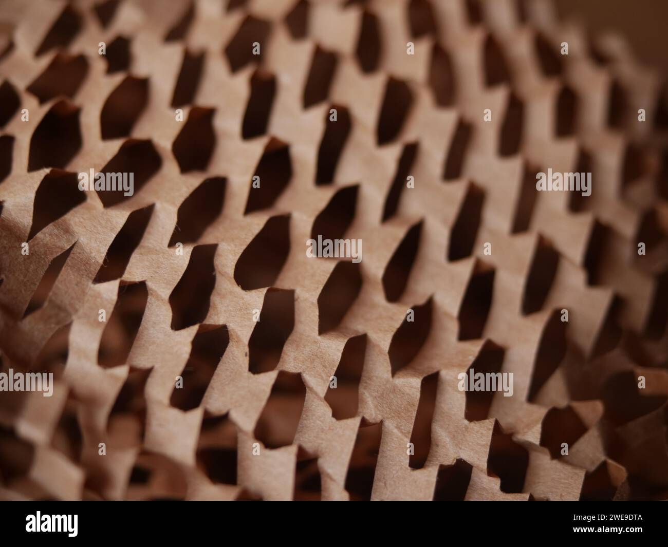 Stucco di carta per pacchi. Carta da imballaggio a nido d'ape marrone Kraft con fessure. Primo piano di carta da artigianato schiacciata. Carta da costruzione riciclata. Posiziona per testo Foto Stock