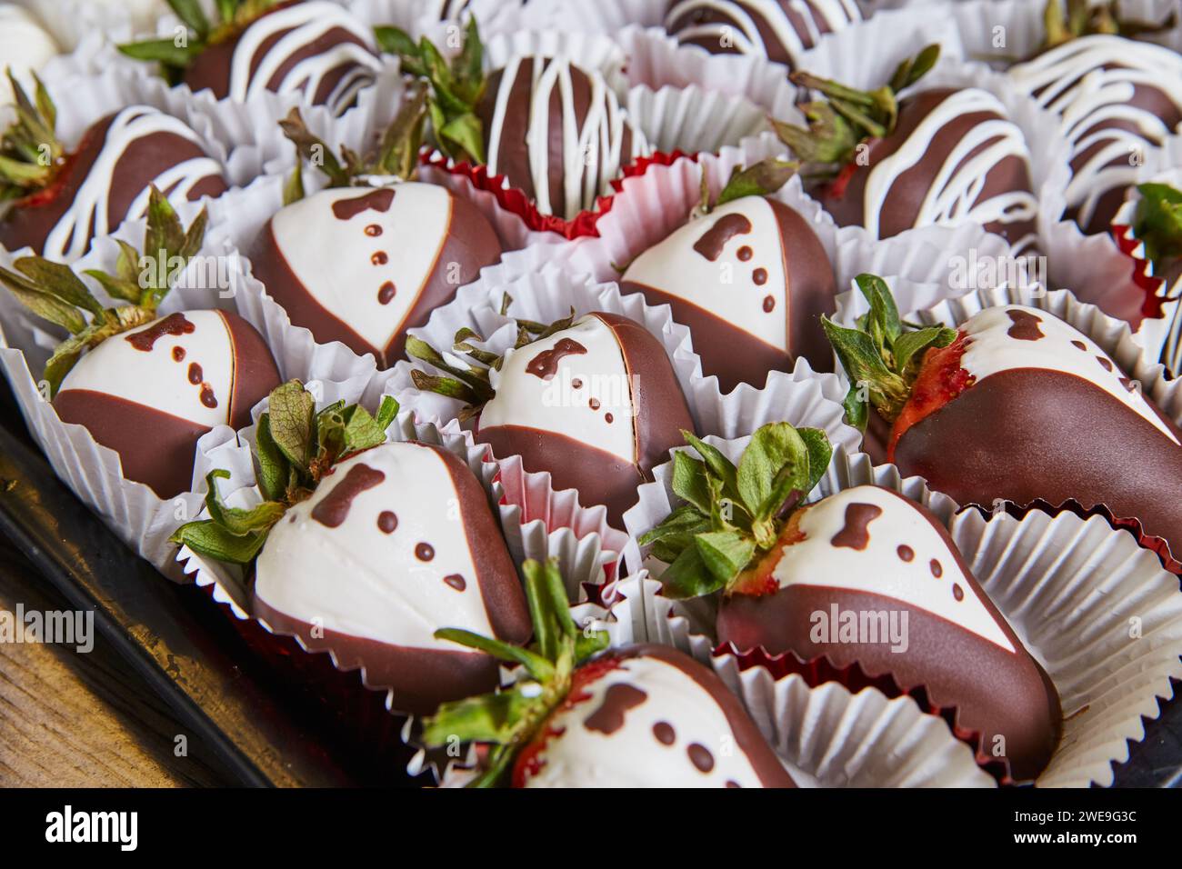 Primi piani di fragole di cioccolato Tuxedo da buongustai in tazze di carta Foto Stock