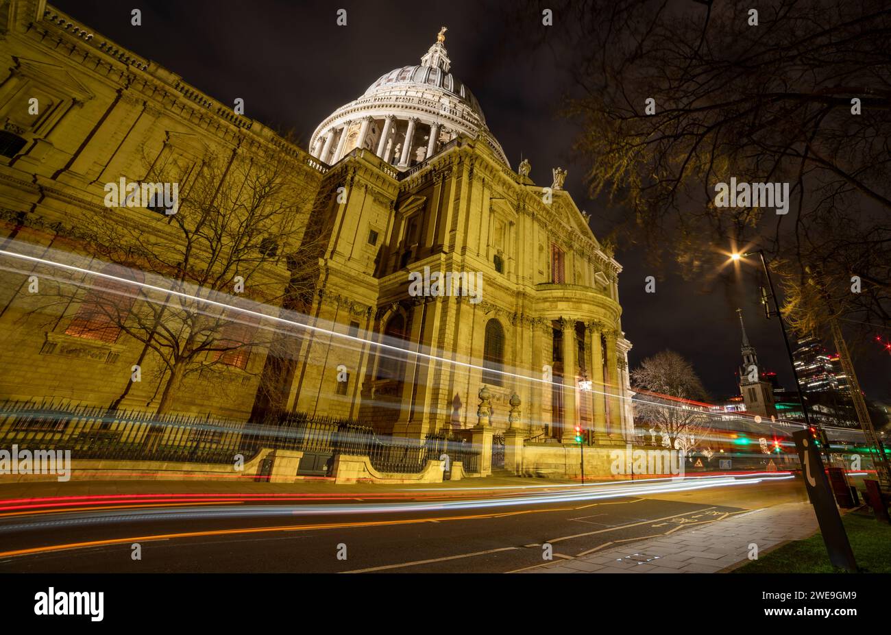 Londra. UK-01.20.2024. Una lunga esposizione notturna vista della strada di St Paul's Cathedral con grattacieli sullo sfondo e sentieri luminosi per veicoli. Foto Stock