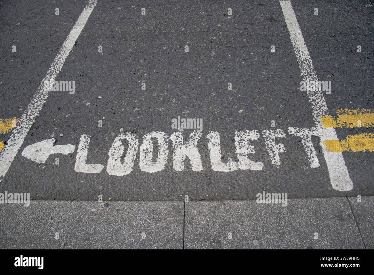 Guarda l'indicazione a sinistra sulla strada asfaltata a Dublino Foto Stock