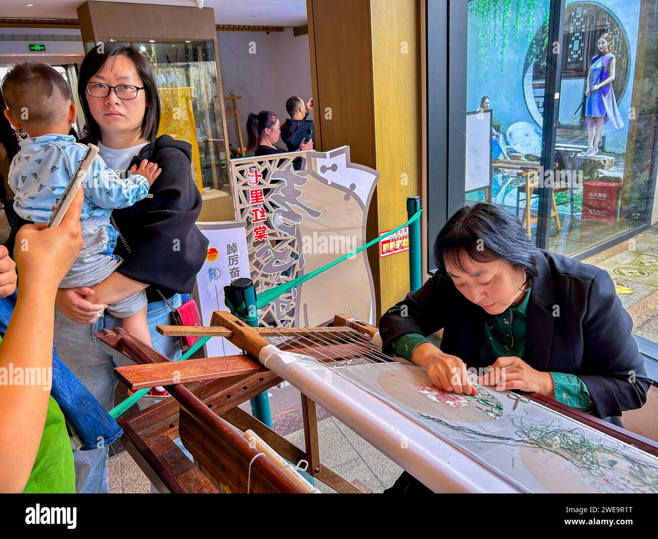 Suzhou, Cina, donna cinese che lavora alla progettazione di tessuti in seta all'interno del Workshop, 'Guild Hall for the Chamber of Commerce of Linghan' Foto Stock
