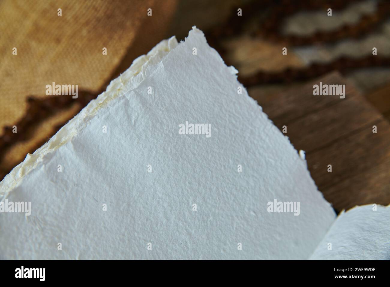Carta bianca strappata su sfondo marrone caldo Foto Stock