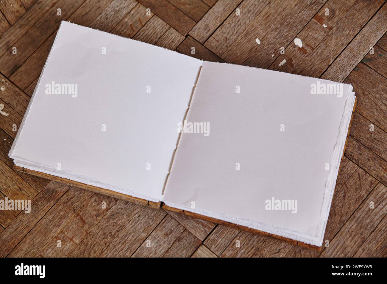 Libro bianco artigianale su legno di spina di pesce, vista dall'alto Foto Stock