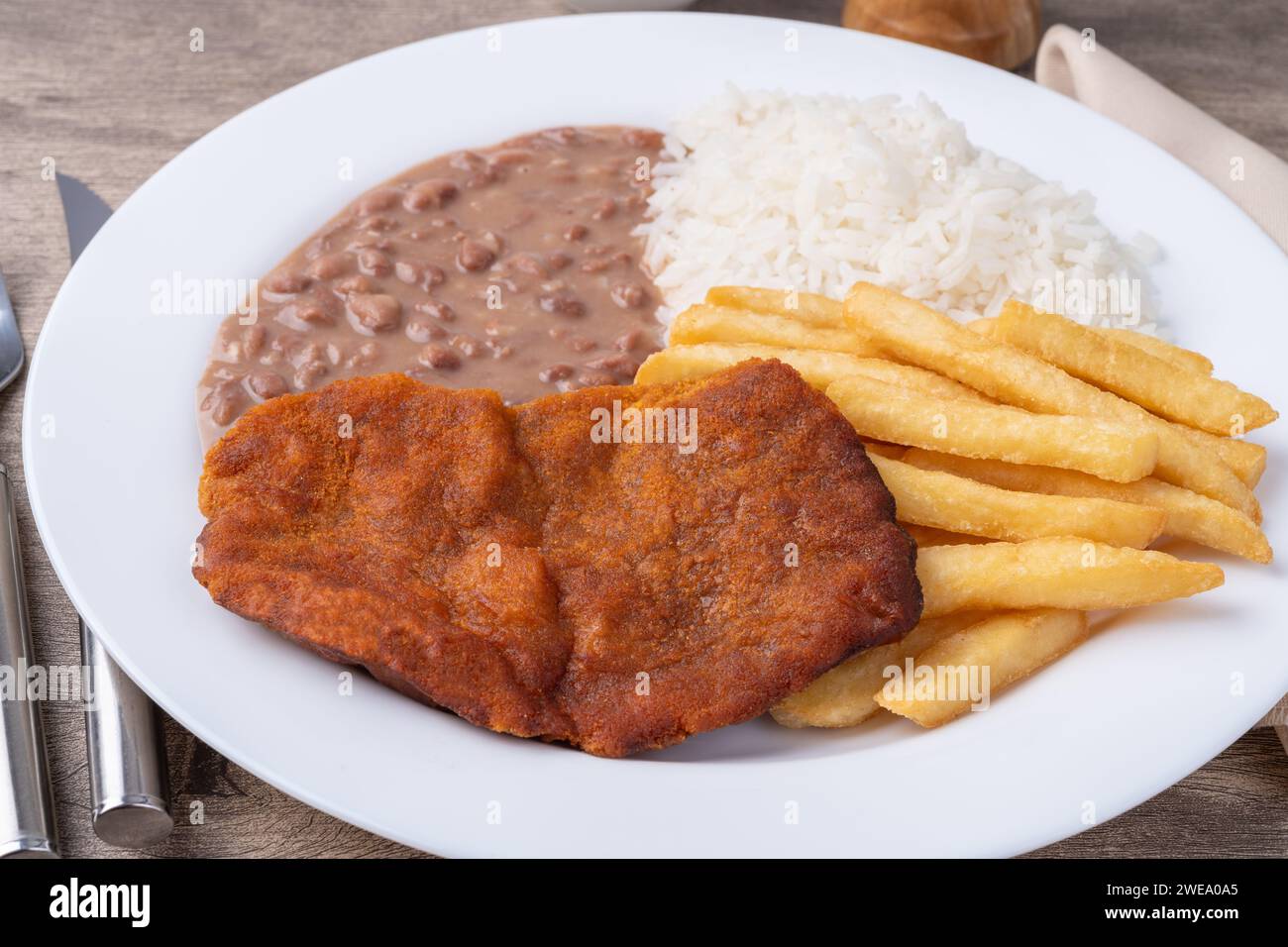 Manzo milanese, riso, fagioli e patatine fritte. Tipico piatto esecutivo brasiliano. Foto Stock