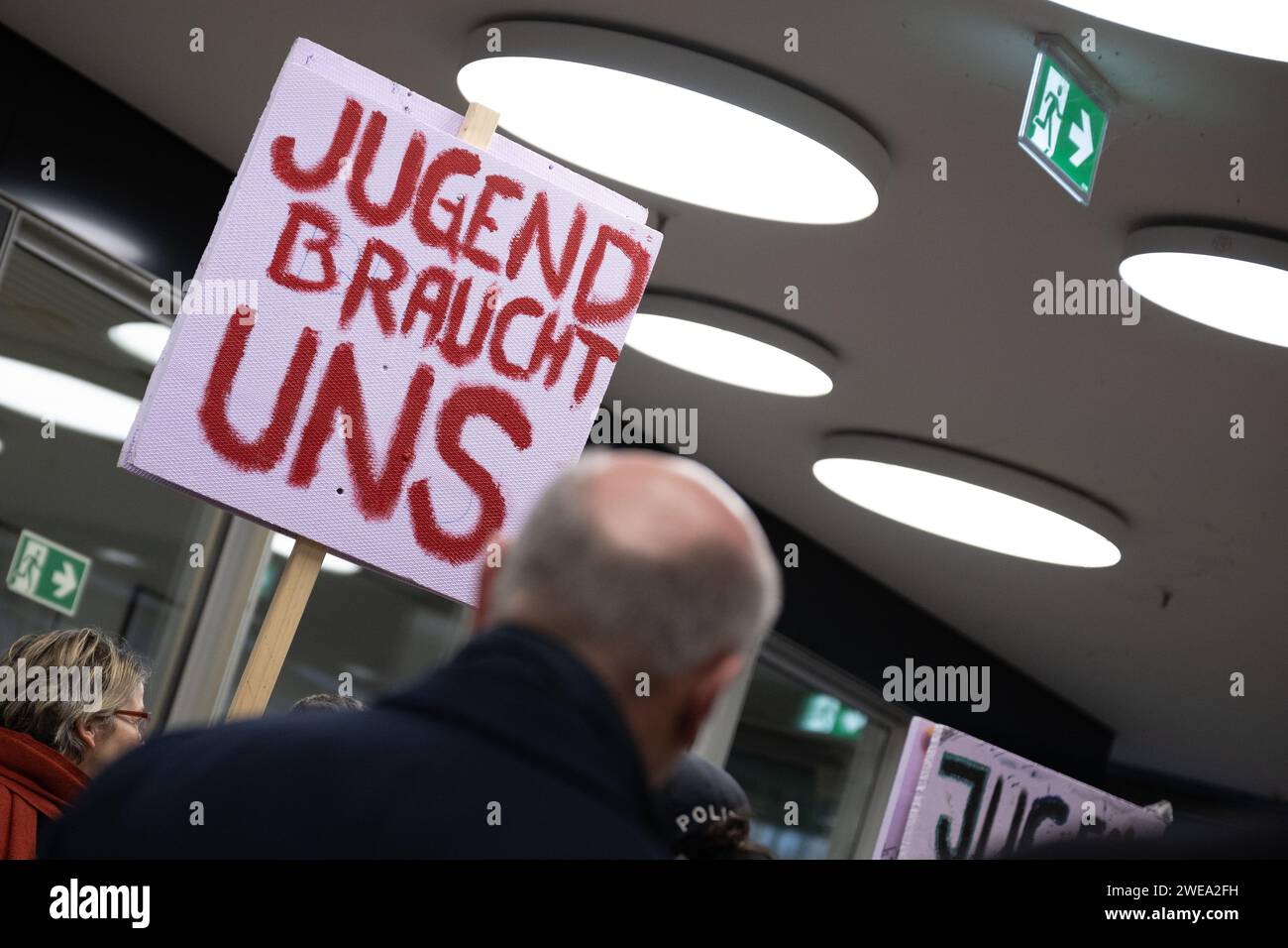 Berlino, Germania. 23 gennaio 2024. Kai Wegner (CDU), sindaco di Berlino, cammina davanti a una manifestazione contro i tagli all'istruzione e all'animazione giovanile durante una visita al Senato di Berlino nel quartiere Friedrichshain-Kreuzberg. Dietro di lui c'è scritto "i giovani hanno bisogno di noi”. Credito: Sebastian Christoph Gollnow/dpa/Alamy Live News Foto Stock