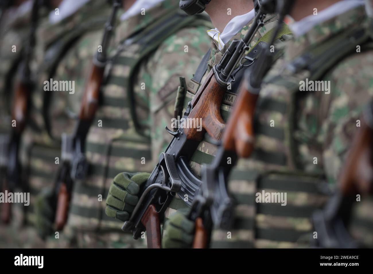 Bucarest, Romania - 24 gennaio 2024: Dettagli con un soldato dell'esercito rumeno in possesso di un fucile d'assalto AK 47 durante una cerimonia militare presso il monumento Foto Stock