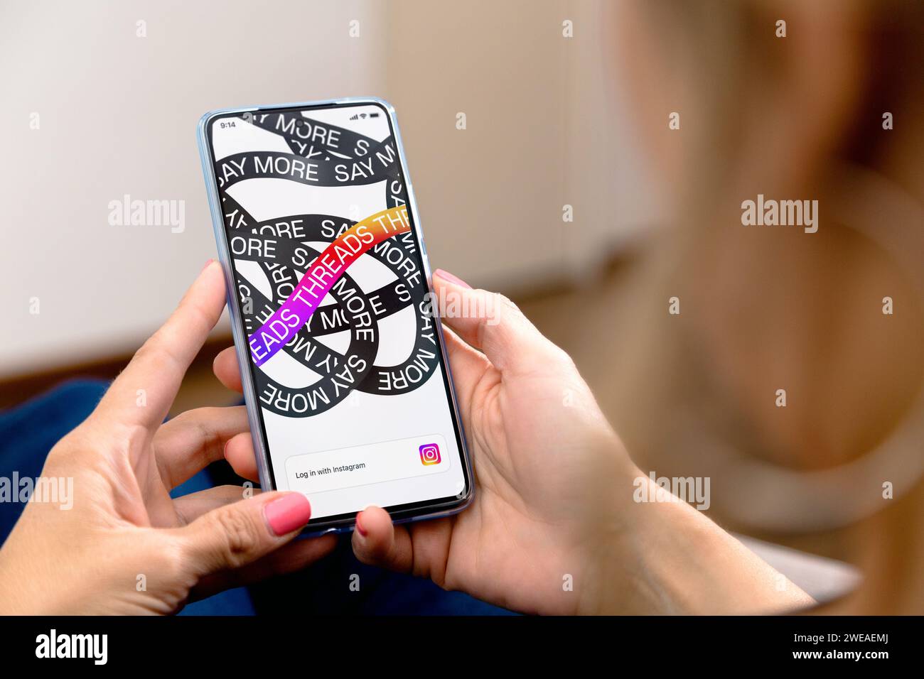 Consente di eseguire il thread dell'apertura dell'app in una schermata dello smartphone. Donna con un telefono cellulare in mano. Applicazione di conversazione basata su testo. Social network come twitter. Foto Stock