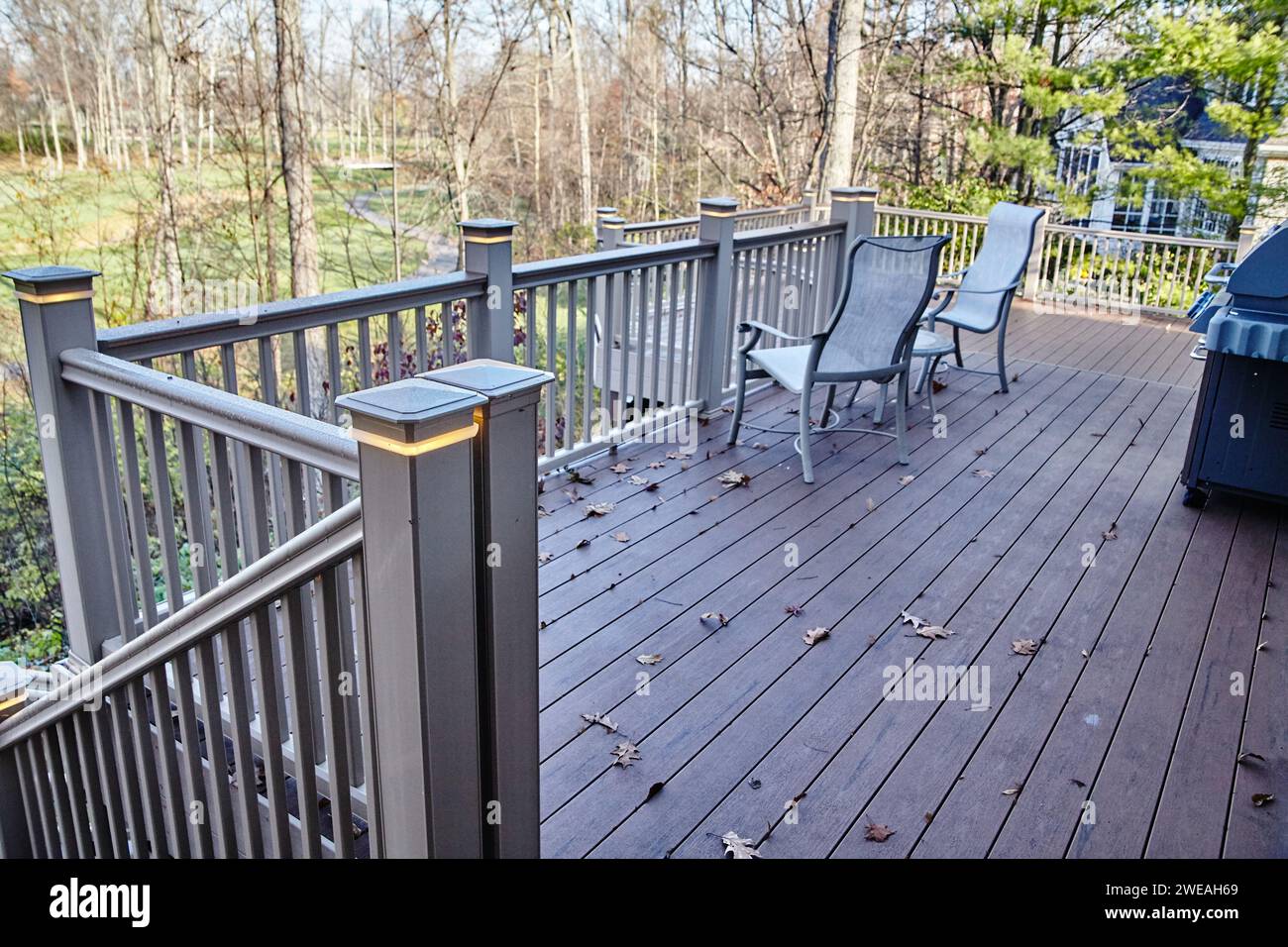 Cortile tranquillo con terrazza in legno e sedie Adirondack Foto Stock