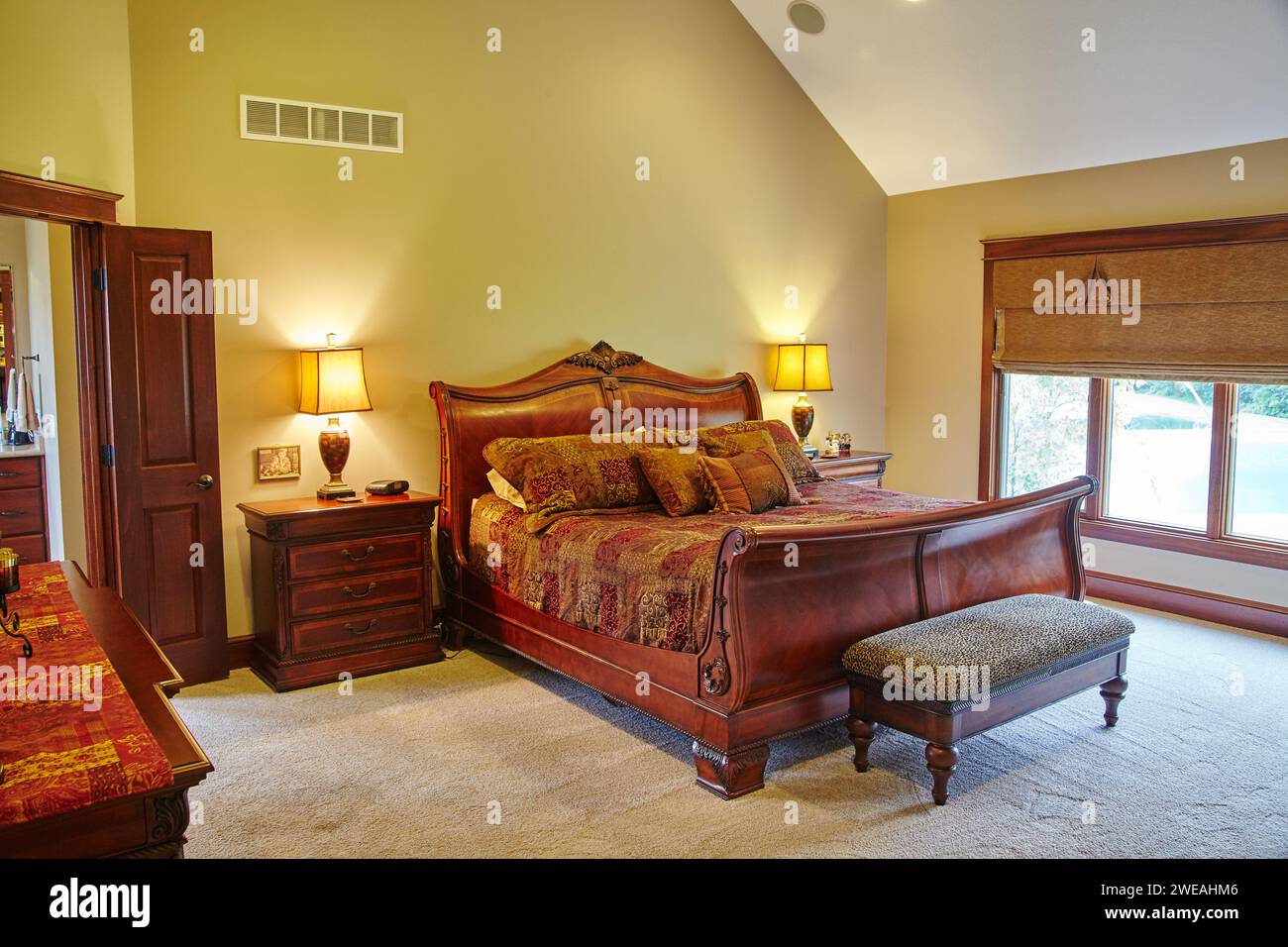 Lussuosa camera da letto tradizionale con eleganti letti rossi e oro e un'atmosfera intima Foto Stock