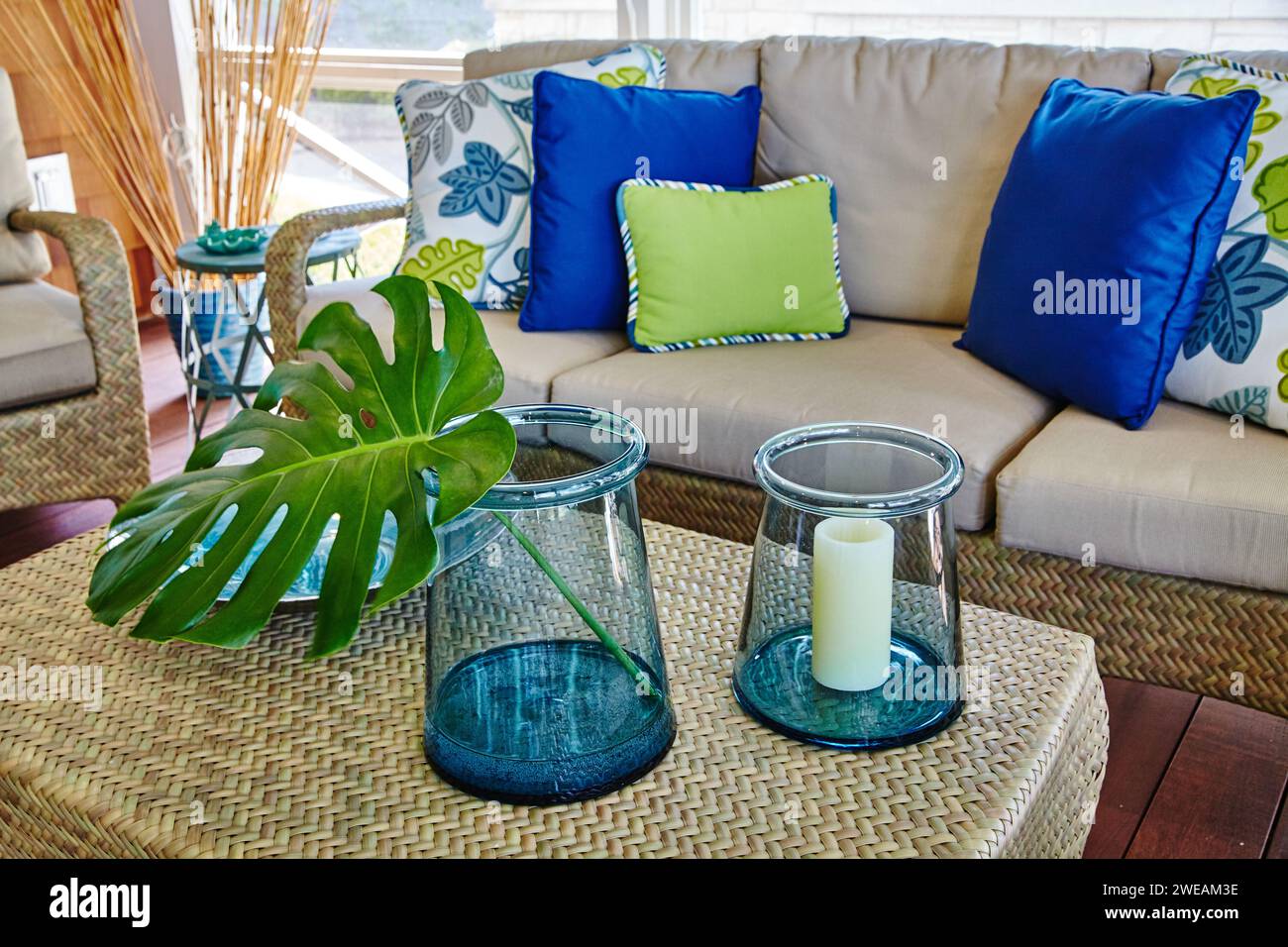 Accogliente camera Sunroom con arredamento Monstera e candela, comoda area salotto Foto Stock