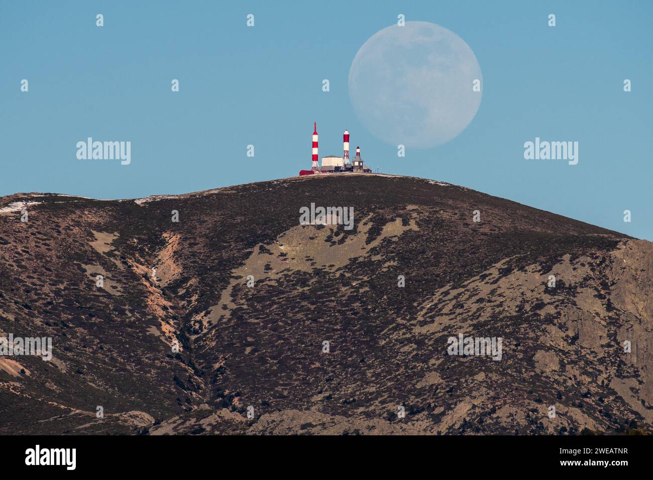 Madrid, Spagna. 24 gennaio 2024. Una luna quasi piena di gennaio (nota come Wolf Moon) sorge sul centro televisivo spagnolo di Bola del Mundo, inaugurato nel 1959, situato a Navacerrada, a 2.262 metri di altezza. Crediti: Marcos del Mazo/Alamy Live News Foto Stock