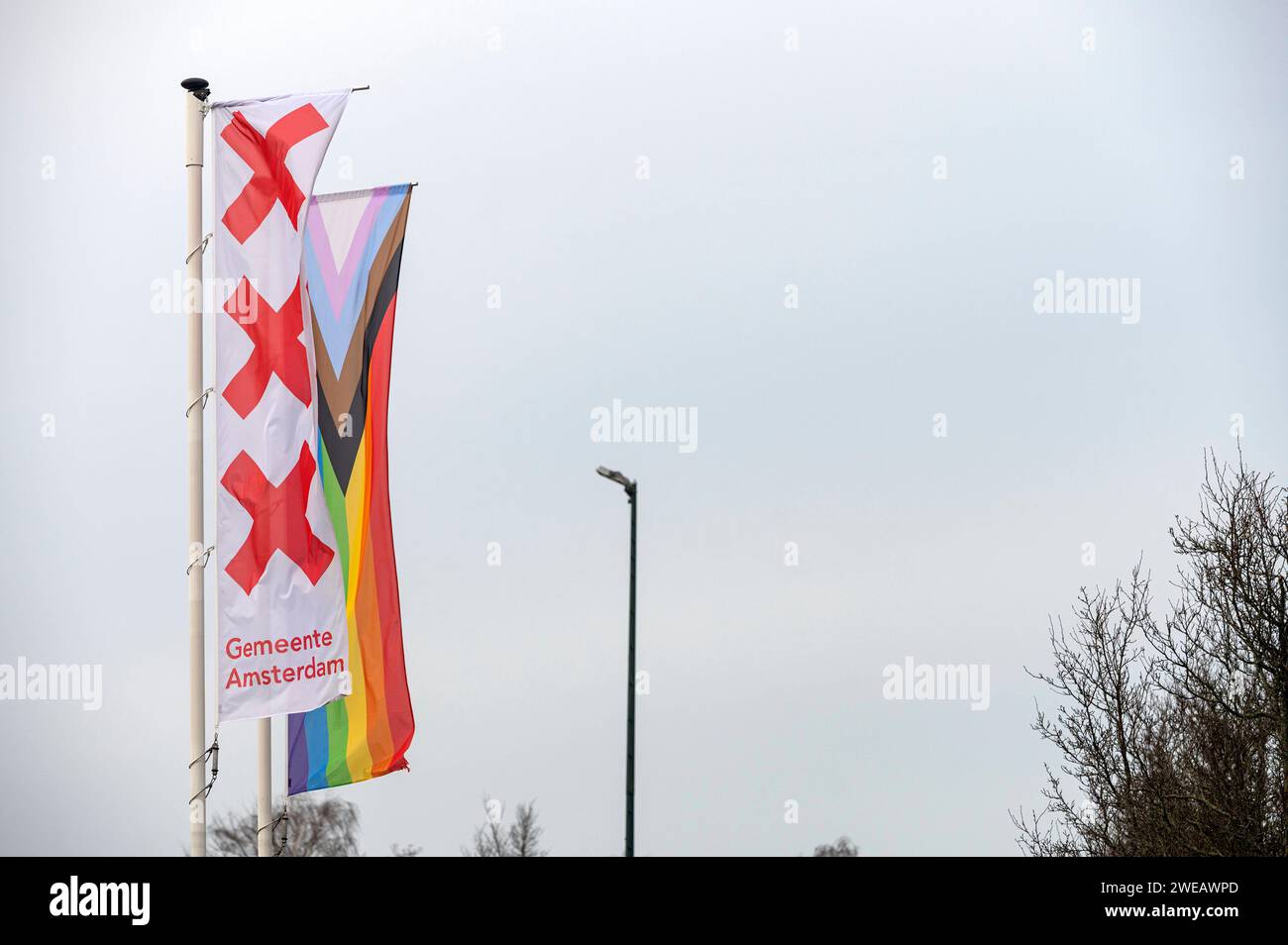 Amsterdam Paesi Bassi 24 gennaio 2024 Un campo sportivo nella città con bandiere del consiglio Gemeente Amsterdam e LGBTQ dutch, nl, vlaggen, lgbtqi, lgbtq Foto Stock