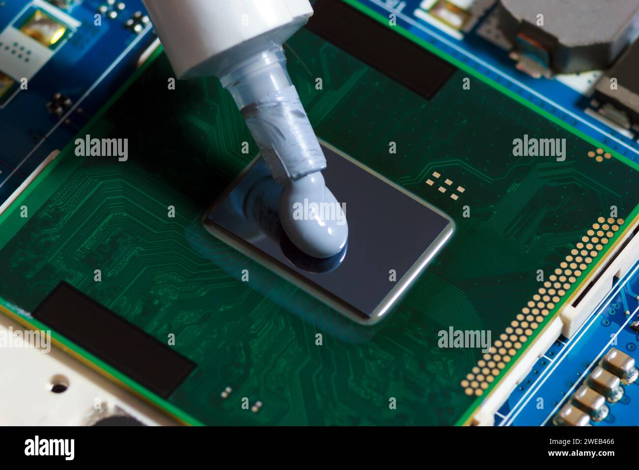 Pressione del composto per pasta termica sul processore del notebook. Grasso termico per un migliore raffreddamento della CPU. Foto Stock