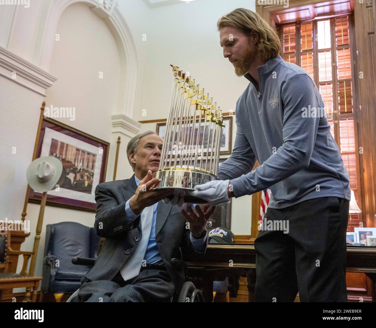 Il lanciatore dei Texas Rangers Jon Gray (a destra) indossa i guanti per consegnare il Commissioner's Trophy al governatore del Texas Greg Abbott durante un'opportunità fotografica nell'ufficio del governatore. I Rangers sconfissero gli Arizona Diamondbacks lo scorso autunno vincendo la loro prima vittoria nelle World Series. Crediti: Bob Daemmrich/Alamy Live News Foto Stock