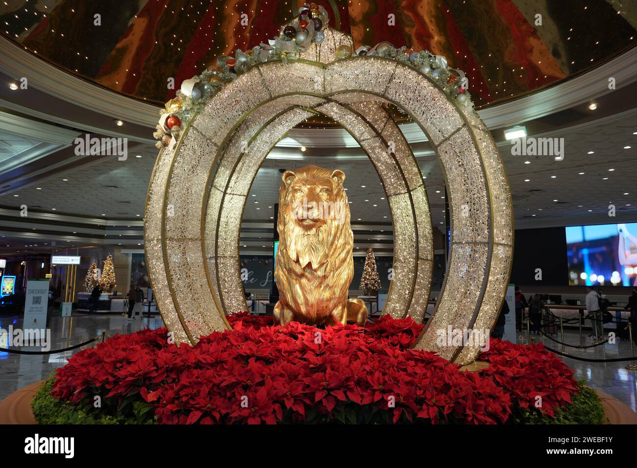 La mascotte dello studio cinematografico Metro-Goldwyn-Mayer Leo the Lion è circondata da ornamenti natalizi nella hall del MGM Grand hotel e casinò, venerdì 1 dicembre 2023, a Las Vegas. Foto Stock