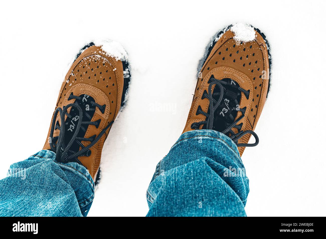 Primo piano di un uomo con scarponi da lavoro in piedi solo sui piedi della neve Foto Stock