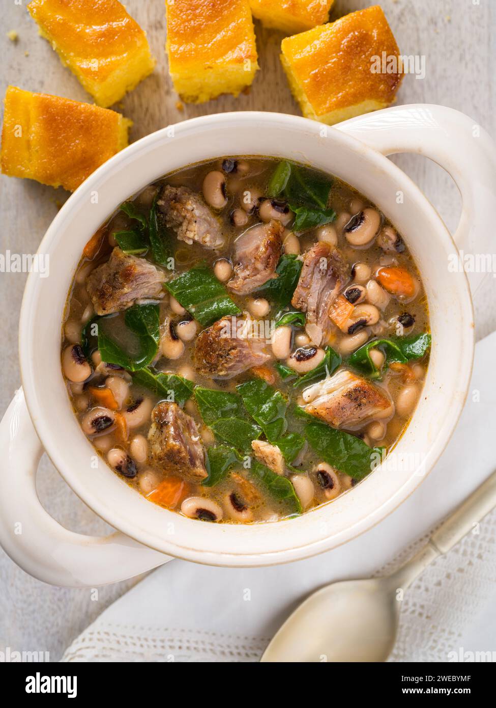 Vista dall'alto dei piselli dagli occhi neri del sud, delle verdi collarine e del maiale con pane di mais Foto Stock