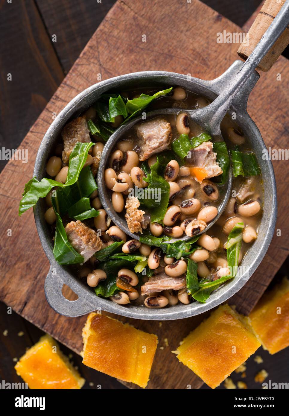 Vista dall'alto dei piselli dagli occhi neri del sud, delle verdi collarine e del maiale con pane di mais Foto Stock