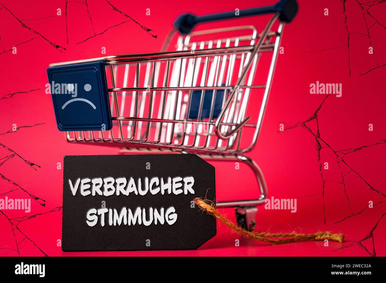 24 gennaio 2024: Carrello della spesa con un sorriso negativo triste, sfondo sgretolato e un'etichetta con l'iscrizione: Consumer Sentiment FOTOMONTAGE *** Einkaufswagen mit einem traurigen negativen Smiley, bröckelnden Hintergrund und einem Etikett mit Aufschrift: Verbraucherstimmung FOTOMONTAGE Foto Stock