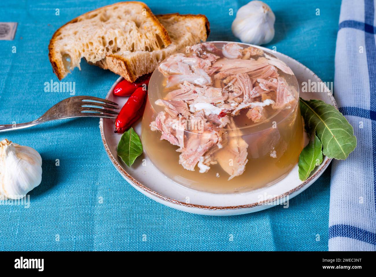 Gelatina con carne, aspic di manzo, piatto tradizionale. porzione sul piatto con pane fatto in casa e peperoncino. Foto Stock