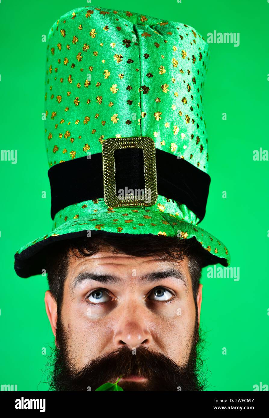 Festa del giorno di San Patrizio. Uomo pensivo in cappello verde alla festa di Patrick. Ritratto di primo piano con una barba seria in un cappello verde leprechaun Foto Stock
