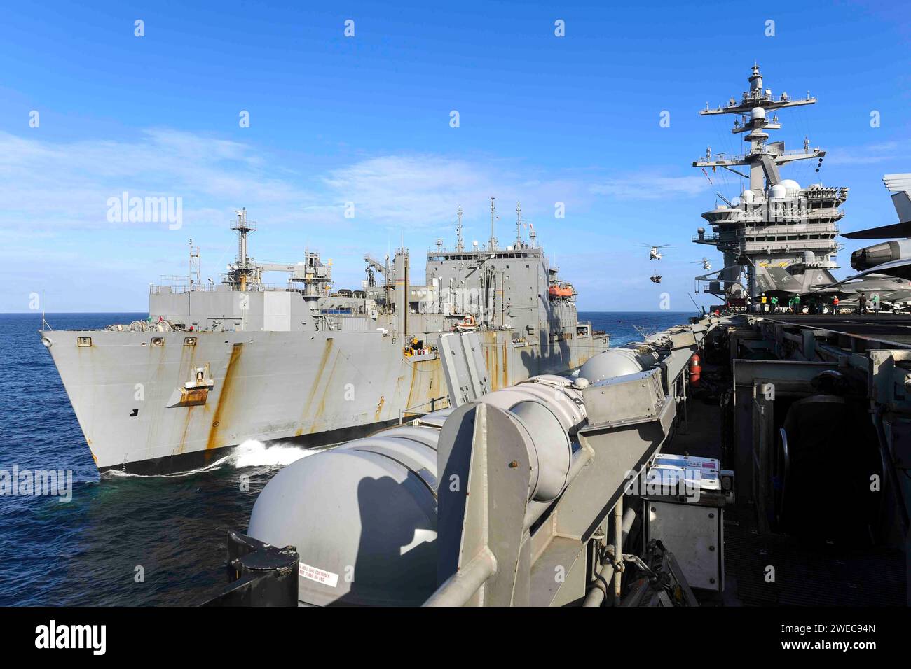 240119-N-TL932-1028 SOUTH CHINA SEA (19 gennaio 2024) la portaerei di classe Nimitz USS Carl Vinson (CVN 70) effettua un rifornimento in mare con la nave Dry Cargo di classe Lewis e Clark USNS Carl Brashear (T-AKE 7). La Vinson, ammiraglia del Carrier Strike Group ONE, è dispiegata nell'area operativa della settima flotta degli Stati Uniti a sostegno di una Indo-Pacifico libera e aperta. (Foto della Marina degli Stati Uniti di Mass Communication Specialist 3rd Class Joshua Sapien) Foto Stock