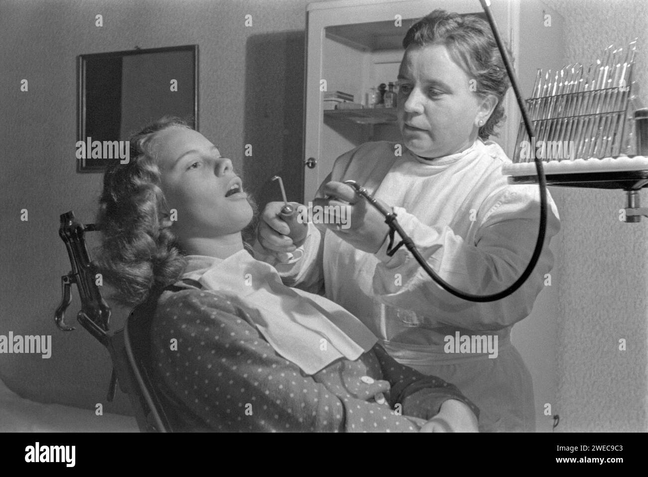 giovane ragazza che ha un trattamento dentale da dentista donna 1950s ungheria Foto Stock